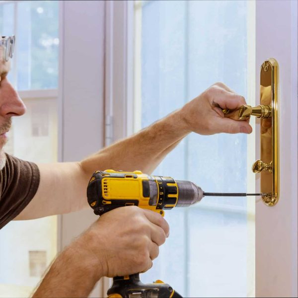 Closeup of a professional locksmith installing or repairing a new deadbolt lock